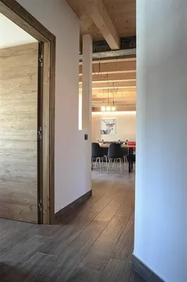an open hallway with a dining room with a table at Apartment El Molin - Alpe Cermis Dolomites in Cavalese