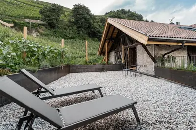 a patio with a chair and a table and a building at Bäcksteinerhof in Merano