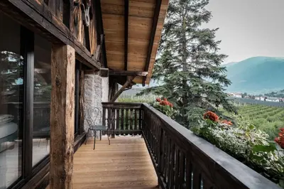 a balcony of a house with a view of the mountains at Bäcksteinerhof in Merano