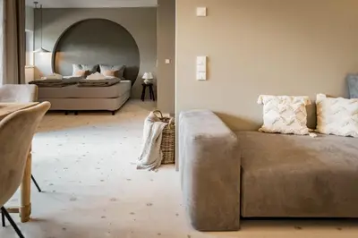 a living room with a couch and a bed at Bäcksteinerhof in Merano