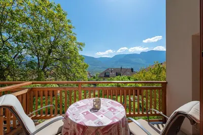 a table and chairs on a balcony with a view at Haus Bellutti in Termeno