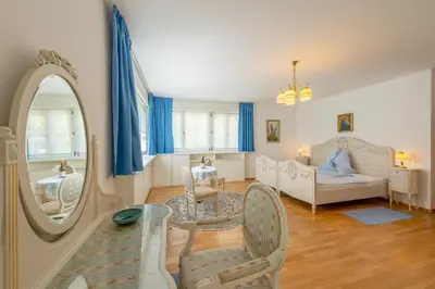 a living room with a mirror and a bed at Haus Bellutti in Termeno