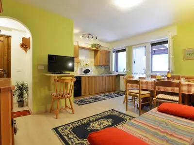 a living room with a table and chairs and a bed at Apartment Des Alpes-13 by Interhome in Canazei