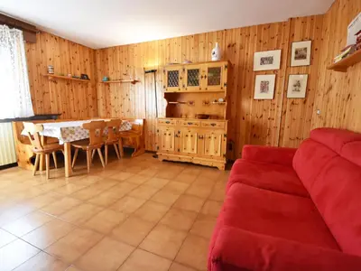 a living room with a red couch and wooden walls at Apartment Des Alpes-14 by Interhome in Canazei