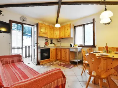 a kitchen and dining room with a table and chairs at Apartment Condominio al Parco-4 by Interhome in Canazei