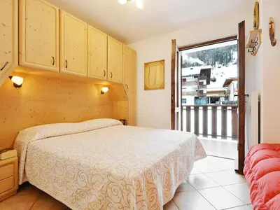 a bedroom with a bed with wooden cabinets at Apartment Condominio al Parco-4 by Interhome in Canazei