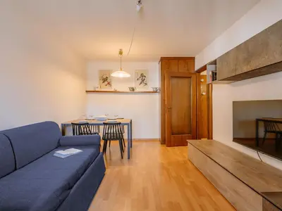 a living room with a blue couch and a table at Apartment Condominio al Parco-5 by Interhome in Canazei
