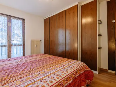 a bedroom with a bed and wooden cabinets at Apartment Condominio al Parco-5 by Interhome in Canazei