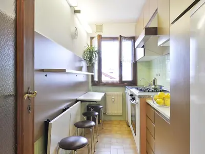 a kitchen with a counter and stools in it at Apartment Condominio al Parco-5 by Interhome in Canazei