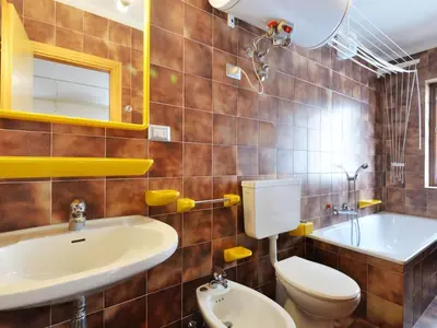 a bathroom with a sink and a toilet and a mirror at Apartment Cesa Fraines-2 by Interhome in Alba di Canazei