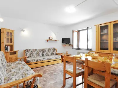 a living room with a table and a couch at Apartment Cesa Fraines-2 by Interhome in Alba di Canazei