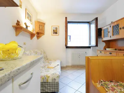 a kitchen with white appliances and a wooden table at Apartment Condominio al Parco-2 by Interhome in Canazei