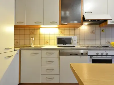 a kitchen with white cabinets and a microwave at Apartment Condominio al Parco-2 by Interhome in Canazei