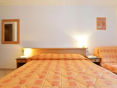 a hotel room with two beds and a telephone at Apartment Condominio al Parco-2 by Interhome in Canazei