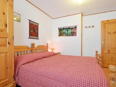 a bedroom with a large bed with a red blanket at Apartment Monti Pallidi-3 by Interhome in Canazei