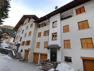 a large white building with snow on the ground at Apartment Monti Pallidi-3 by Interhome in Canazei