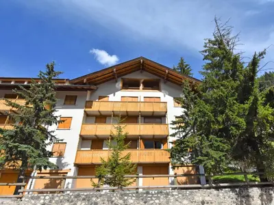 a white building with trees in front of it at Apartment Monti Pallidi-3 by Interhome in Canazei