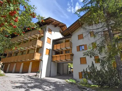 a white building with wooden balconies on it at Apartment Monti Pallidi-3 by Interhome in Canazei