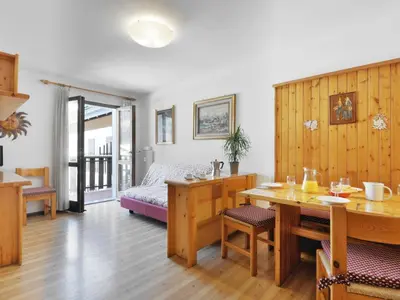 a room with a bed and a table and a dining room at Apartment Condominio al Parco-1 by Interhome in Canazei