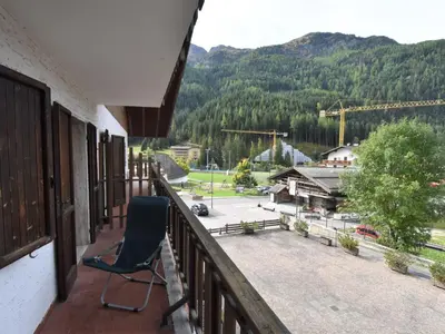 a chair on a balcony with a view of a mountain at Apartment Condominio al Parco-1 by Interhome in Canazei