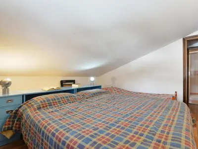 a bedroom with a bed and a blue dresser at Apartment Condominio al Parco-7 by Interhome in Canazei