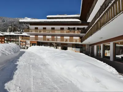 a snow covered road in front of a building at Apartment Condominio al Parco-7 by Interhome in Canazei