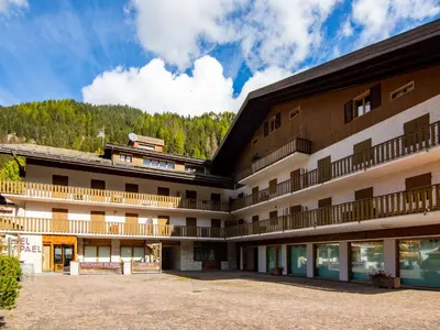 a large building with a mountain in the background at Apartment Condominio al Parco-7 by Interhome in Canazei