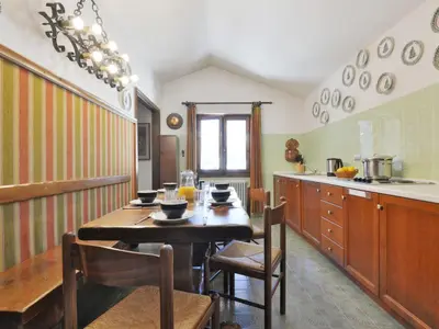 a kitchen with a table and chairs in a kitchen at Apartment Condominio al Parco-7 by Interhome in Canazei