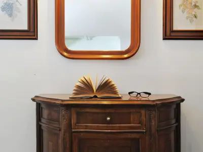 a table with a mirror and a book and glasses at Apartment Condominio al Parco-7 by Interhome in Canazei
