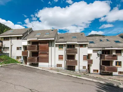 a row of apartment buildings with solar panels on them at Apartment Enrosadira-5 by Interhome in Alba di Canazei