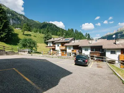 a car parked in a parking lot in front of buildings at Apartment Enrosadira-5 by Interhome in Alba di Canazei