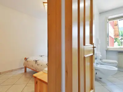 a bathroom with a sink and a toilet and a bed at Apartment Villa Placidia Apt 24 by Interhome in Campitello di Fassa
