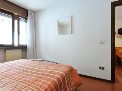 a bedroom with a bed and a window at Apartment Des Alpes-15 by Interhome in Canazei