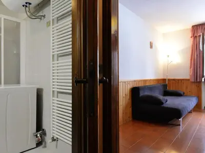a living room with a couch and a bed at Apartment Des Alpes-15 by Interhome in Canazei