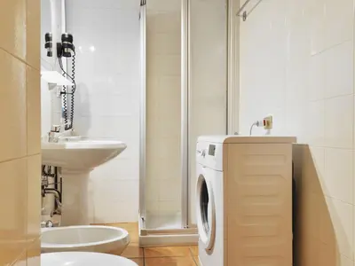 a bathroom with a washing machine and a sink at Apartment Apt 2 by Interhome in Canazei