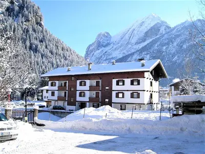 a building in the snow in front of a mountain at Apartment Cesa Palua by Interhome in Alba di Canazei