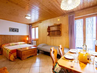 a bedroom with a bed and a table and chairs at Apartment Apt 39 by Interhome in Alba di Canazei