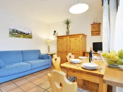 a living room with a blue couch and a table at Apartment Apt 1 by Interhome in Canazei