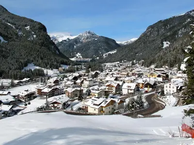 a village covered in snow with mountains in the background at Apartment Apt 1 by Interhome in Canazei
