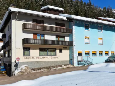 a blue and white building with snow in front of it at Apartment Apt 3 by Interhome in Canazei