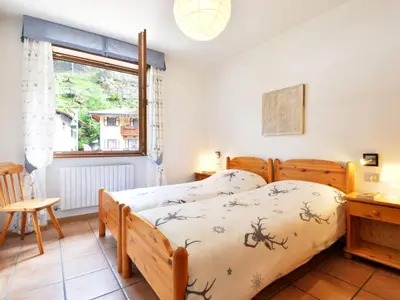 a bedroom with a bed and a desk and a window at Apartment Apt 3 by Interhome in Canazei