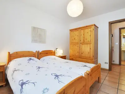 a bedroom with a bed and a wooden cabinet at Apartment Apt 3 by Interhome in Canazei