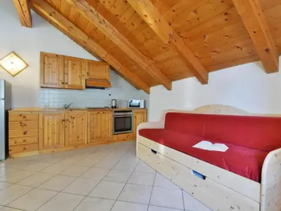 a living room with a red couch and wooden ceilings at Apartment Villa Placidia Apt 33 by Interhome in Campitello di Fassa