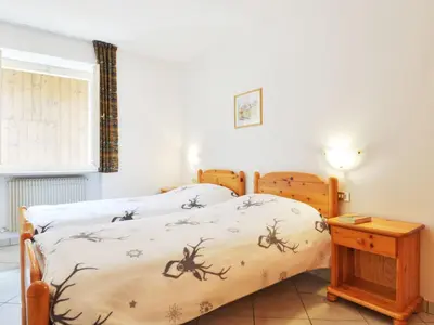 a bedroom with a bed and a table and a window at Apartment Villa Placidia Apt 21 by Interhome in Campitello di Fassa