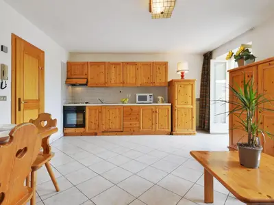 a kitchen with wooden cabinets and a wooden table at Apartment Villa Placidia Apt 21 by Interhome in Campitello di Fassa
