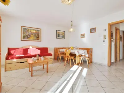 a living room with a red couch and a table at Apartment Villa Placidia Apt 21 by Interhome in Campitello di Fassa
