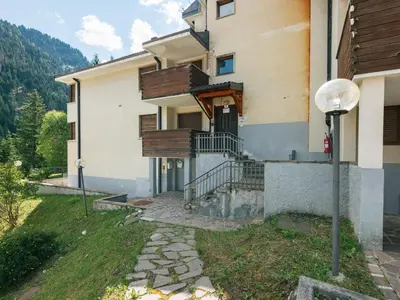 a house on a hill with mountains in the background at Apartment Enrosadira-6 by Interhome in Alba di Canazei