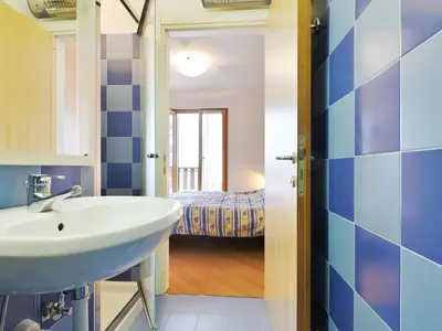 a bathroom with a sink and a bedroom at Apartment Condominio al Parco-3 by Interhome in Canazei