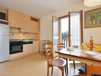 a living room with a table and a blue couch at Apartment Condominio al Parco-3 by Interhome in Canazei
