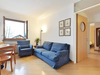 a living room with a blue couch and a table at Apartment Condominio al Parco-3 by Interhome in Canazei